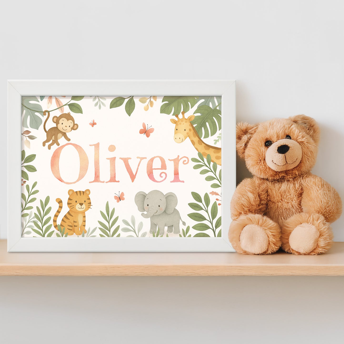 Personalised framed children's name print with animal illustrations in a jungle safari theme next to a teddy bear on a shelf.